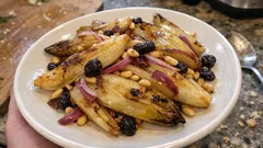 Restovaná endivie na pánvi s rozinkami a piniovými oříšky – hotovo za pár minut